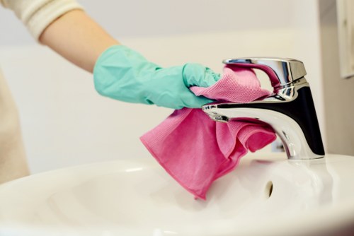 Cleaner treating stains on a sofa in a Belsizepark flat during a local upholstery service